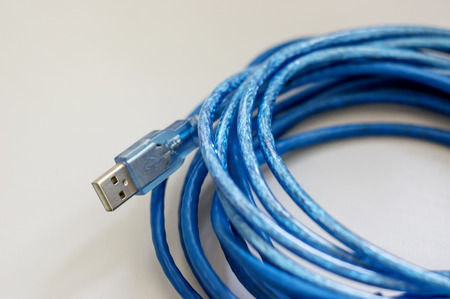 Blue USB cable on a desk, soft focus.の写真素材