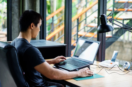 Man using a laptop in the room.の写真素材