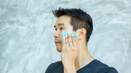 Man use oil remover paper on his face.の写真素材