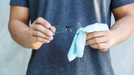 Man cleaning the glasses with microfiber fabric.の写真素材
