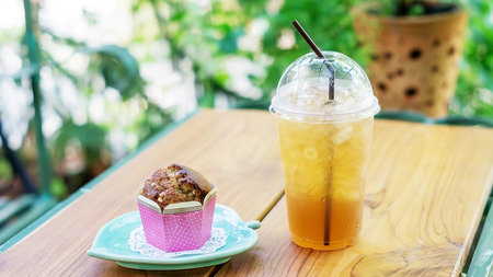 muffin cake and ice tea on a wooden table.の写真素材