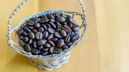 coffee beans in the basket on the wooden background.の写真素材