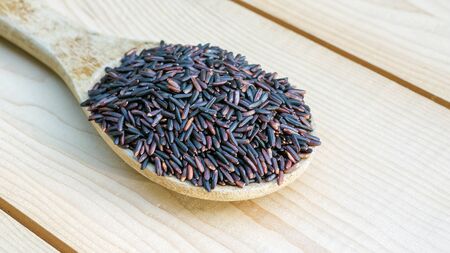 Rice berry in a wooden spoon.の写真素材