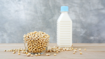 soybean in a bowl and soy milk on a wooden background.の写真素材