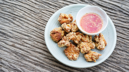 deep fried chicken and spicy sauce on a wooden background.の写真素材