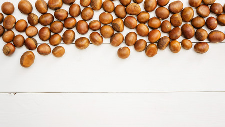 Chestnuts on a white wooden table.の写真素材