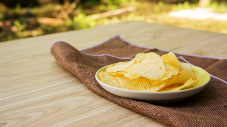potatoes chips on a wooden table.の写真素材