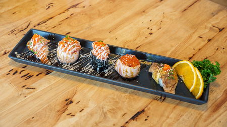Fresh salmon eggs sushi on a black plate (Japanese food).の写真素材