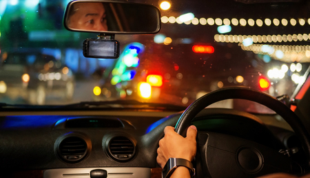 Men driving a car at night.の写真素材