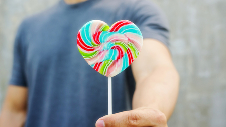 Man holding a lollipop on a gray .の写真素材