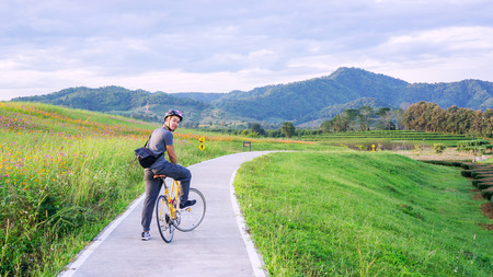 Men riding a bicycle near a lake at Singha park Chiang Rai, Thailand.