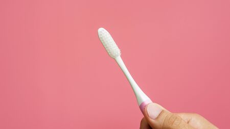 Men holding new toothbrush on a pink background.の写真素材