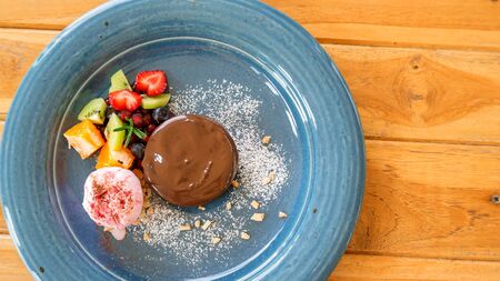Chocolate cake lava and strawberry ice cream on a blue plate.