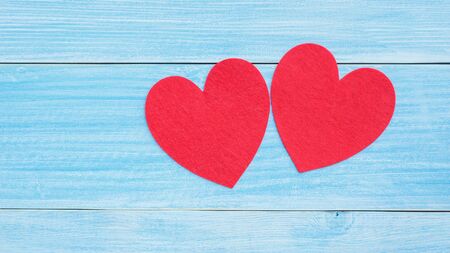Red fabric heart on a blue wooden table.の写真素材