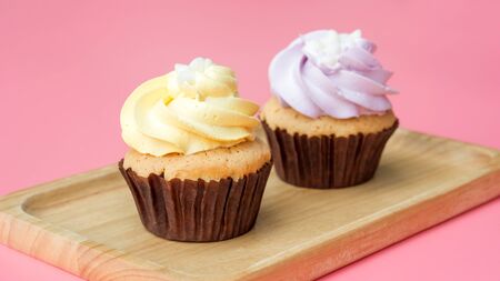Cupcake on a wooden plate and pink background.の写真素材