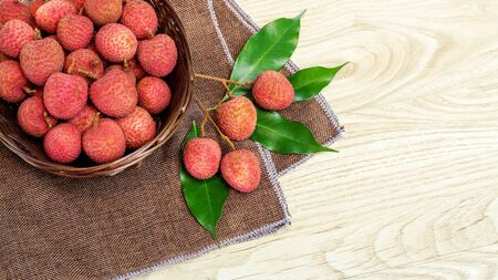 Red lychee fruit on a wooden table.の写真素材