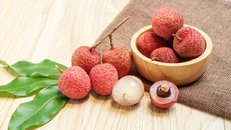 Red lychee fruit on a wooden table.の写真素材