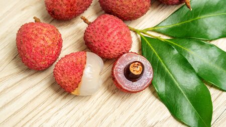 Red lychee fruit on a wooden table.の写真素材