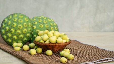 Green lotus seeds on a wooden table.の写真素材