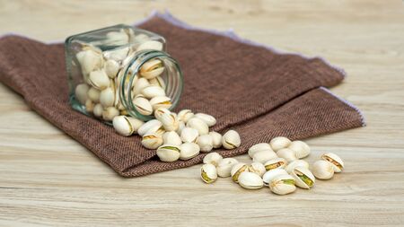Pistachio nuts on a wooden table.の写真素材
