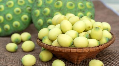 Green lotus seeds on a wooden table.の写真素材