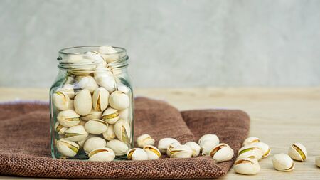 Pistachio nuts on a wooden table.の写真素材