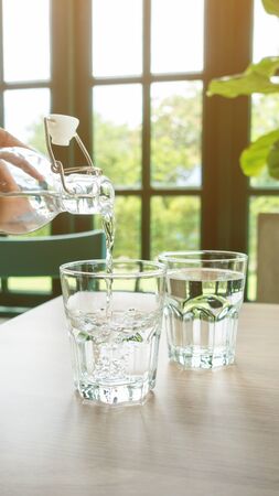 A glass of drinking water on a wooden table.の写真素材