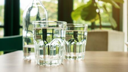 A glass of drinking water on a wooden table.の写真素材