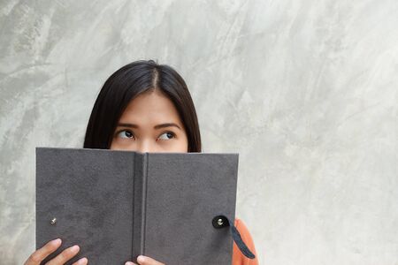 Asian woman reading a book on a grayの写真素材