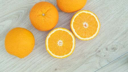 Oranges fruit in a basket on a wooden table.の写真素材