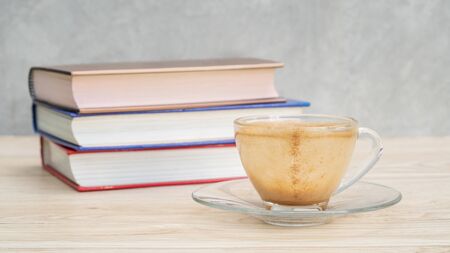 An empty of a cup of coffee and a pile of a book.の写真素材