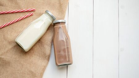 Milk and chocolate milk on a white wooden table.の写真素材