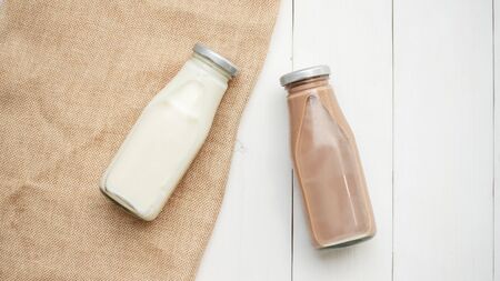 Milk and chocolate milk on a white wooden table.の写真素材