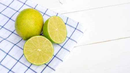 Green lime on a white wooden table.の写真素材