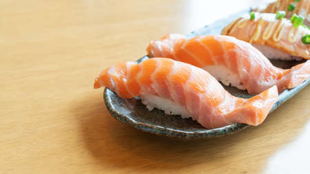 Fresh salmon sushi on a wooden table.の写真素材