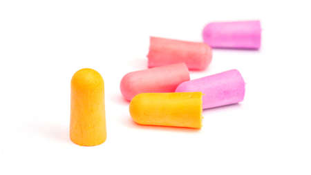 Yellow, violet and pink earplugs on a white background.の写真素材