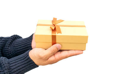 Man holding a gold gift box on a white background.の写真素材
