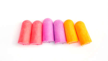 Yellow, violet and pink earplugs on  whiteの写真素材