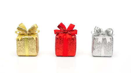 Gold, red, and silver gift box on a white background.の写真素材