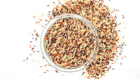 Organic three colors (red, black, and brown) parboiled rice on a white background.の写真素材