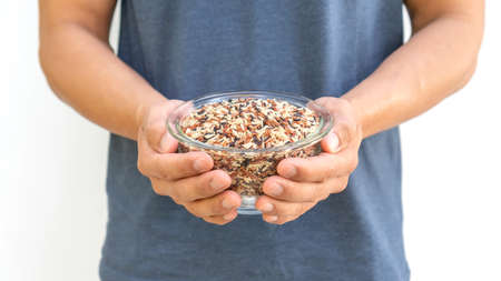 Man holding organic three colors (red, black, and brown) rice on a white background.の写真素材