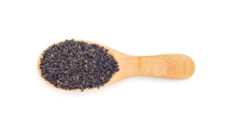 Black sesame seeds in a spoon on a white background.の写真素材