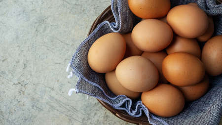 Chicken eggs in a basket on a gray background.の写真素材