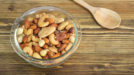 Bake mixed nuts on a wooden table.の写真素材