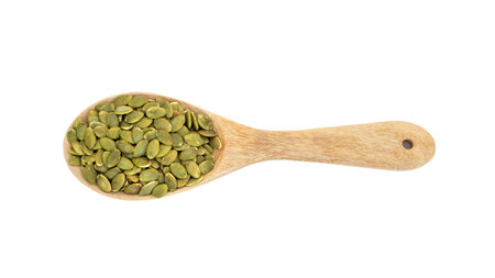 Green pumpkin seeds in a spoon on a white background.の写真素材