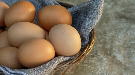Chicken eggs in a basket on a gray background.の写真素材