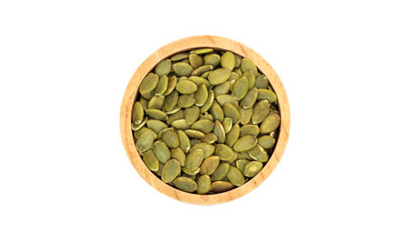 Green pumpkin seeds in a bowl on a white background.の写真素材