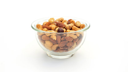 Baked mixed nuts in a bowl on a white background.の写真素材