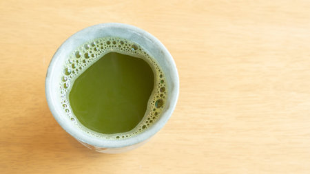 Hot matcha green tea on a wooden table.の写真素材