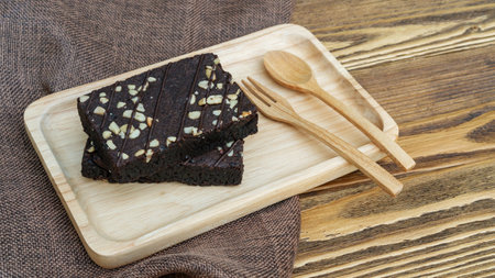 Brownies cake, spoon, and fork on a wooden table.の写真素材